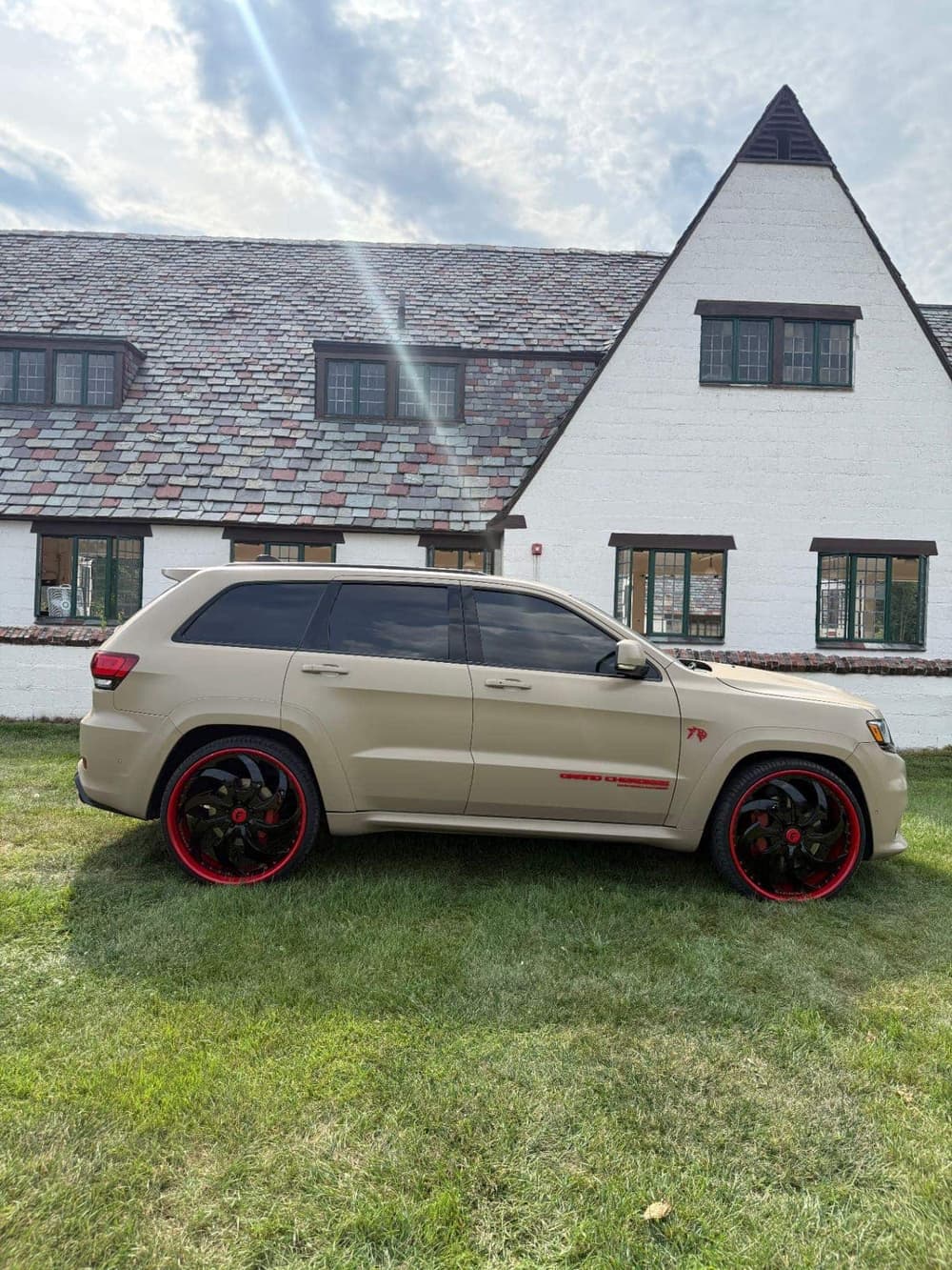 Jeep Grand Cherokee SRT in matte desert tan vinyl wrap on red and black Forgiato wheels by Utica Auto Spa