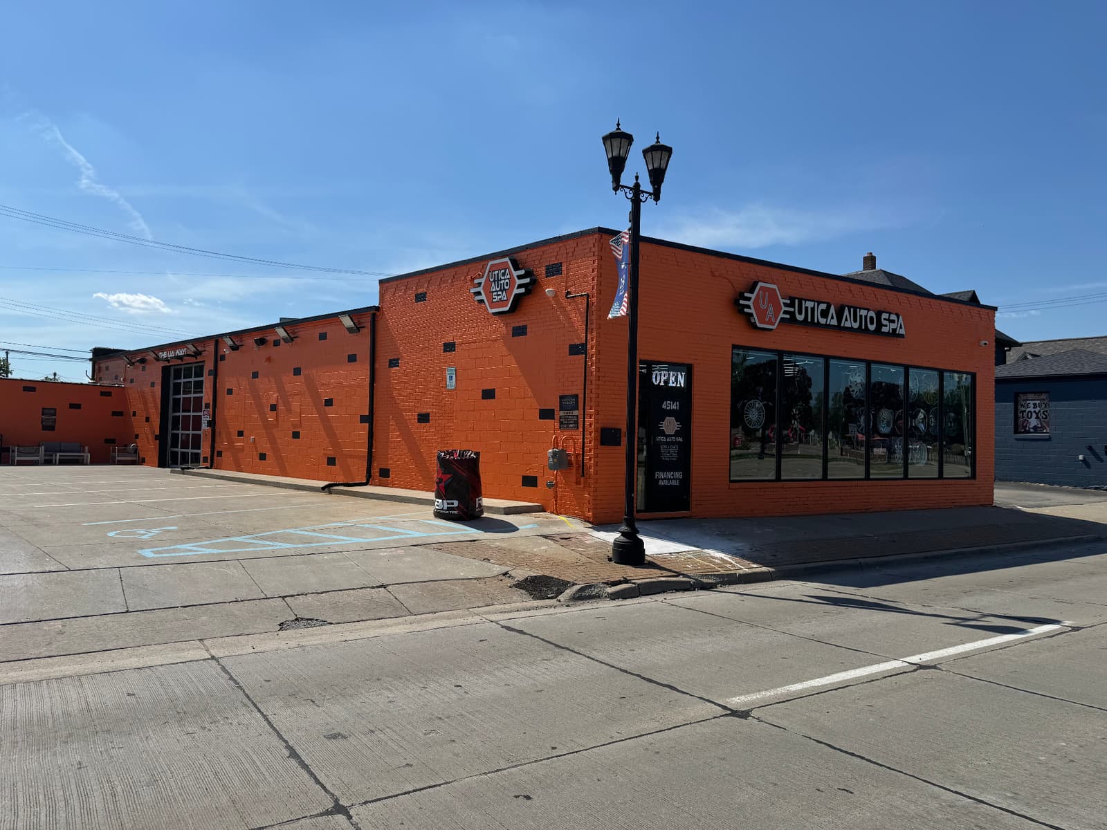 Wide side-angle exterior photo of Utica Auto Spa building and front showroom